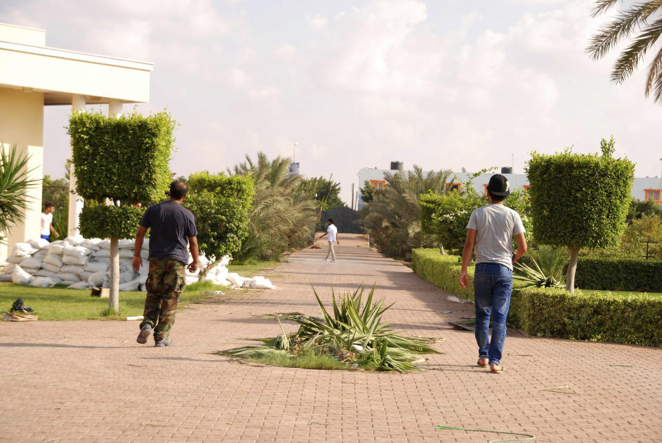 Libyans walk on the grounds of the U.S. consulate in Benghazi, Libya, after an attack that killed four Americans, including Ambassador Chris Stevens, Wednesday, Sept. 12, 2012. (AP Photo/Ibrahim Alaguri)