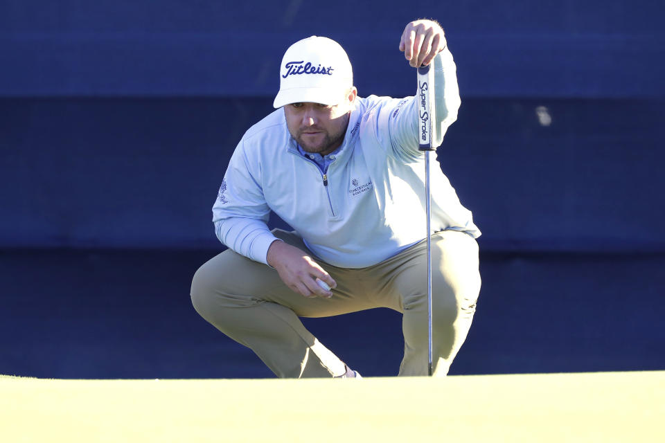 Ben Taylor checks the lie before putting on the 17th green during the third round of the Houston Open golf tournament, Saturday, Nov. 12, 2022, in Houston. (AP Photo/Michael Wyke)