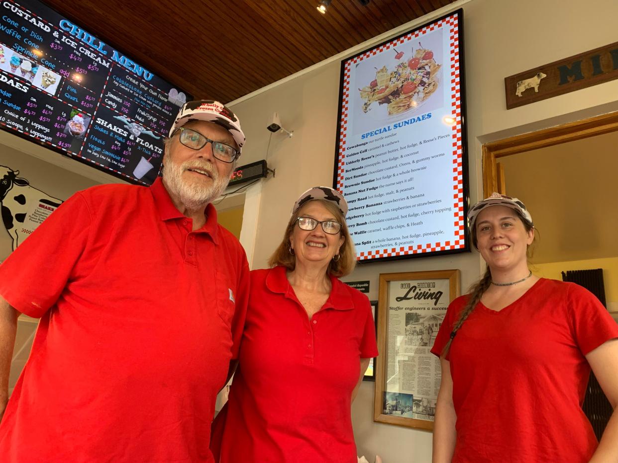 Jim and Jan Stoffer, Wholly Cow's owners, stand with their daughter Susan Sorensen in front of the kitchen ordering counter and menu boards of their frozen custard and burger shop in Delafield's old business district on Main Street. The couple, who started the business in 1992, are retiring, with hopes of selling the business to continue the tradition.