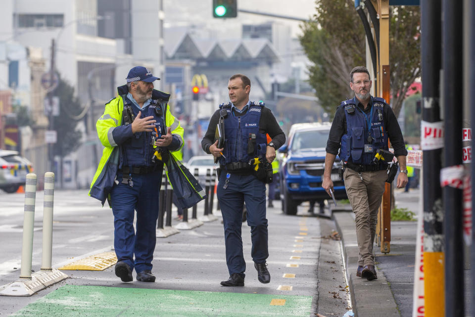 Police officers walk near a fire at a hostel in central Wellington, New Zealand, Tuesday, May 16, 2023. Several people were killed after a fire broke out overnight at the four-story building. (Mark Mitchell/NZ Herald via AP)