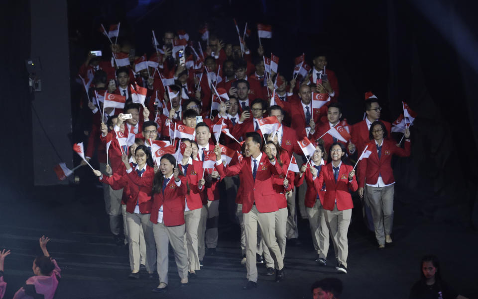Singapore athletes hold flags during the opening ceremony of the 30th South East Asian Games at the Philippine Arena, Bulacan province, northern Philippines on Saturday, Nov. 30, 2019. (AP Photo/Aaron Favila)