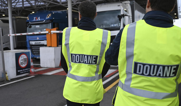FILE - In this Tuesday, Sept. 17, 2019 file photo, French custom officers observe trucks on their way to Great Britain, during a test in case of a no deal Brexit, at the exit of the Channel tunnel in Calais, northern France. Britain and the European Union have struck a provisional free-trade agreement that should avert New Year chaos for cross-border traders and bring a measure of certainty for businesses after years of Brexit turmoil. (Denis Charlet, Pool via AP, File)