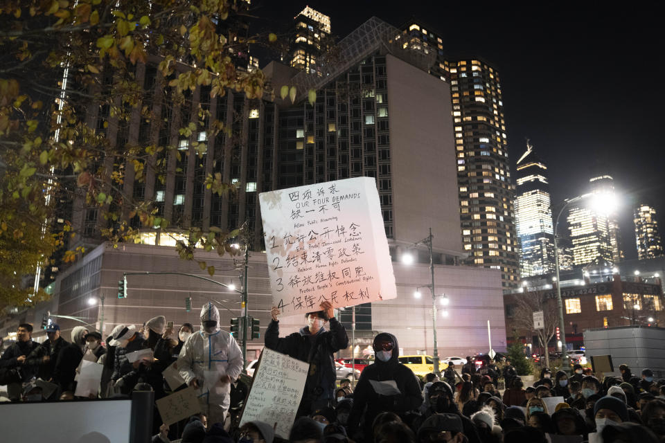 Protesters gather near the Chinese consulate, in background, to stand in solidarity with their counterparts around the world demonstrating against China's severe anti-virus restrictions, Tuesday, Nov. 29, 2022, in New York. Protests in China, which were the largest and most wide spread in the nation in decades, included calls for Communist Party leader Xi Jinping to step down. (AP Photo/John Minchillo)