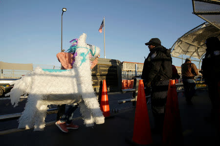 A woman carries a pinata past a U.S. Customs and Border Protection (CBP) agent, while heading to El Paso, Texas, at Paso del Norte international border crossing bridge, in Ciudad Juarez, Mexico April 1, 2019. REUTERS/Jose Luis Gonzalez