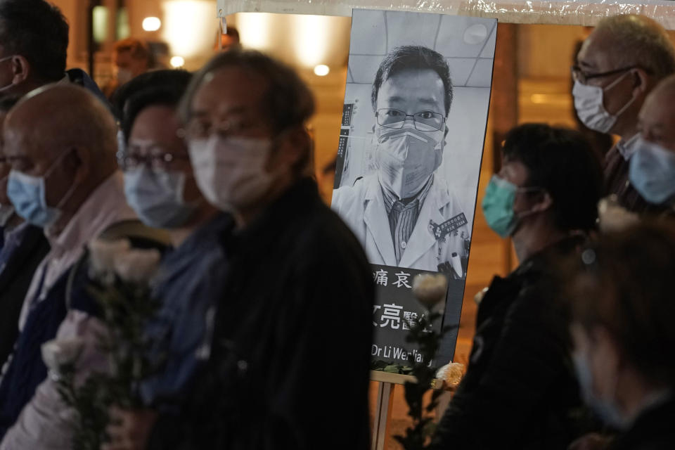 People wearing masks, attend a vigil for Chinese doctor Li Wenliang, in Hong Kong, Friday, Feb. 7, 2020. The death of a young doctor who was reprimanded for warning about China's new virus triggered an outpouring Friday of praise for him and fury that communist authorities put politics above public safety. (AP Photo/Kin Cheung)
