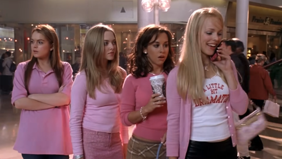 a group of women dressed in pink clothes, one is on the phone