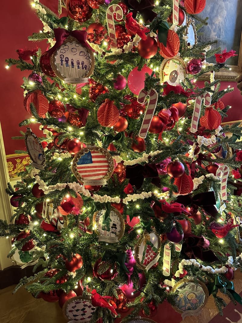 red, gold, and green christmas tree with american flags and lights