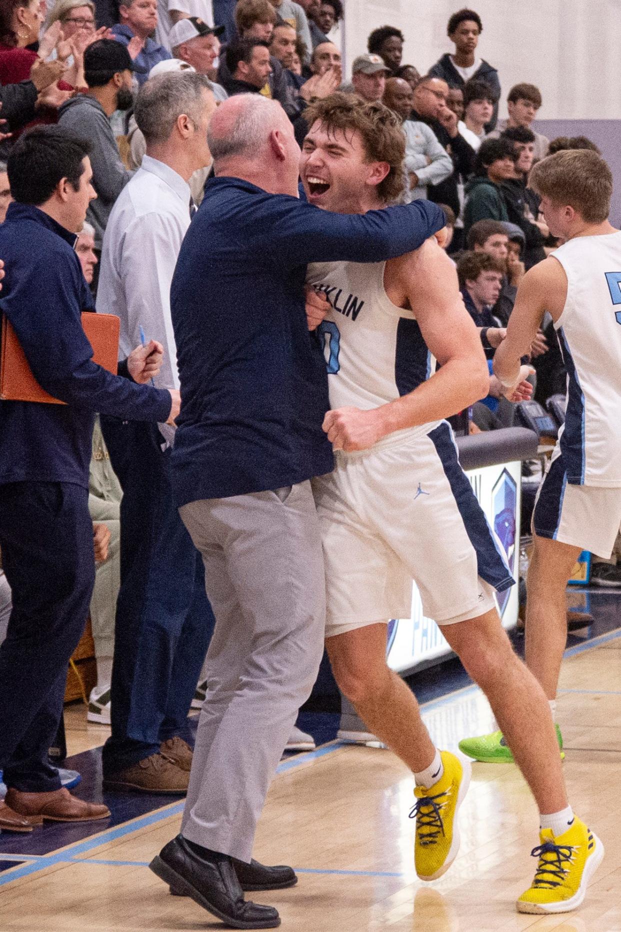 Franklin senior Henry DiGiorgio celebrates with a member of the coaching staff after defeating BC High, 66-49, in the Division 1 Elite 8 game at Franklin High, March 9, 2024.