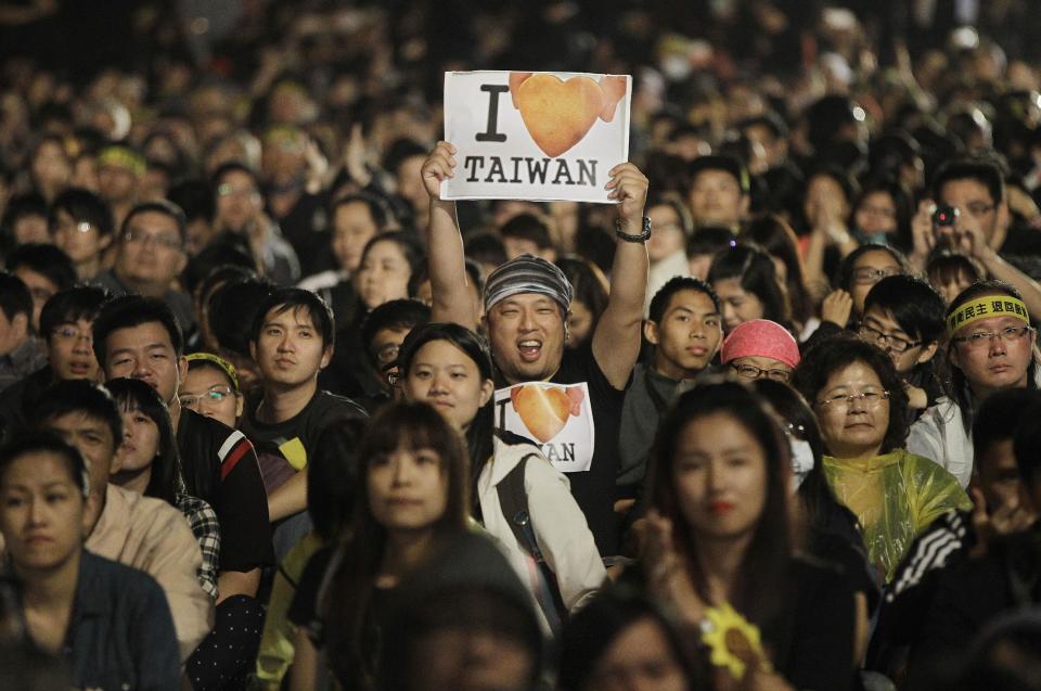 A protester displays a banner supporting Taiwan during a massive protest over the controversial China Taiwan trade pact in front of the Presidential Building in Taipei, Taiwan, Sunday, March 30, 2014. Over a hundred thousand protesters gathered in the rally against the island's rapidly developing ties with the communist mainland. (AP Photo/Wally Santana)