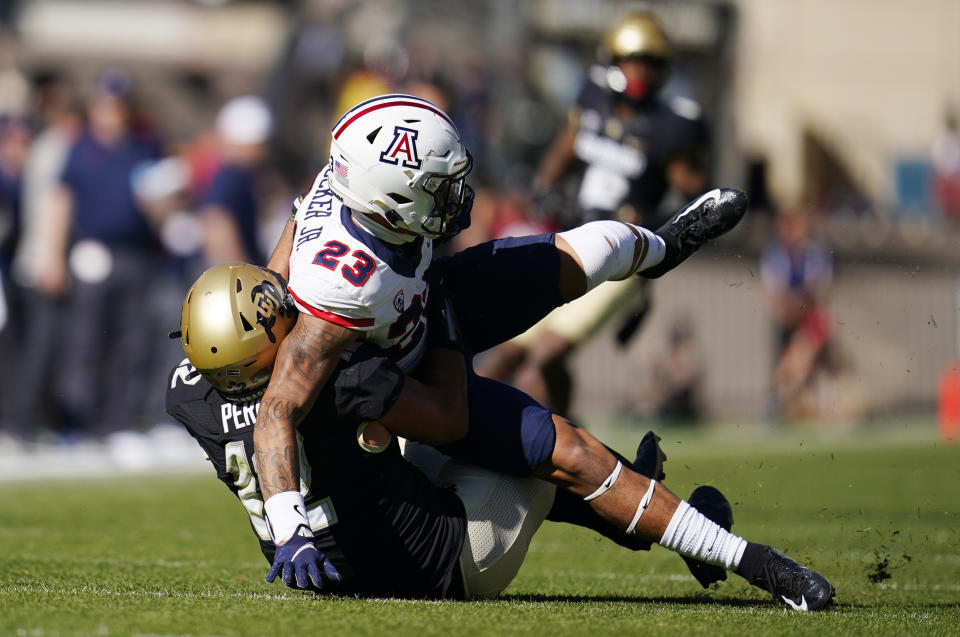 Arizona running back Stevie Rocker Jr., top, is dragged down by Colorado linebacker Quinn Perry in the first half of an NCAA college football game Saturday, Oct. 16, 2021, in Boulder, Colo. (AP Photo/Geneva Heffernan)