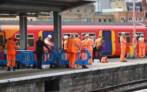 Rail engineers and emergency workers on a platform at Waterloo national rail station after the train derailment - Credit: Victoria Jones/PA