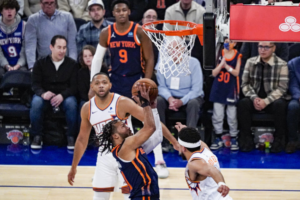 New York Knicks guard Jalen Brunson takes a contested shot over Phoenix Suns guard Devin Booker during the first half of an NBA basketball game in New York, Sunday, Nov. 26, 2023. (AP Photo/Peter K. Afriyie)