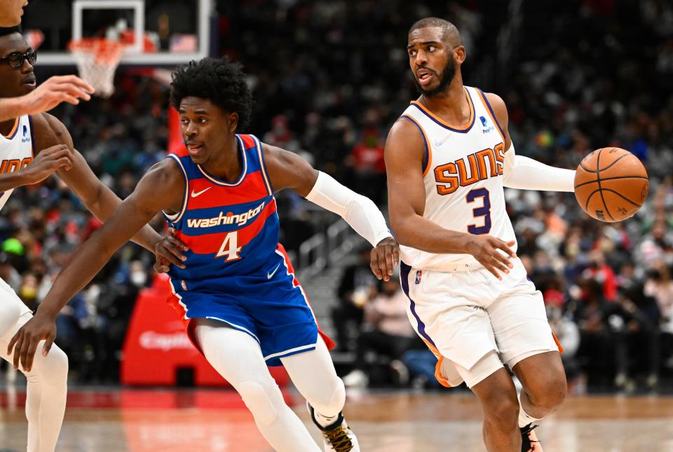 Feb 5, 2022; Washington, District of Columbia, USA; Phoenix Suns guard Chris Paul (3) dribbles past Washington Wizards guard Aaron Holiday (4)  during the first half at Capital One Arena. Mandatory Credit: Brad Mills-USA TODAY Sports