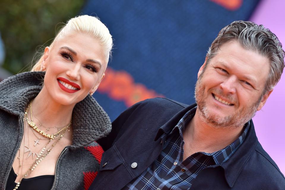 Blake Shelton looking amazing in a blue jacket with stripes T-shirt with Gwen Stefani rocking a grey sweater and pant to match