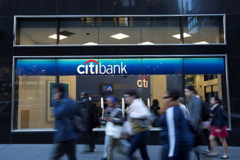 FILE PHOTO: People walk past a Citibank branch in New York