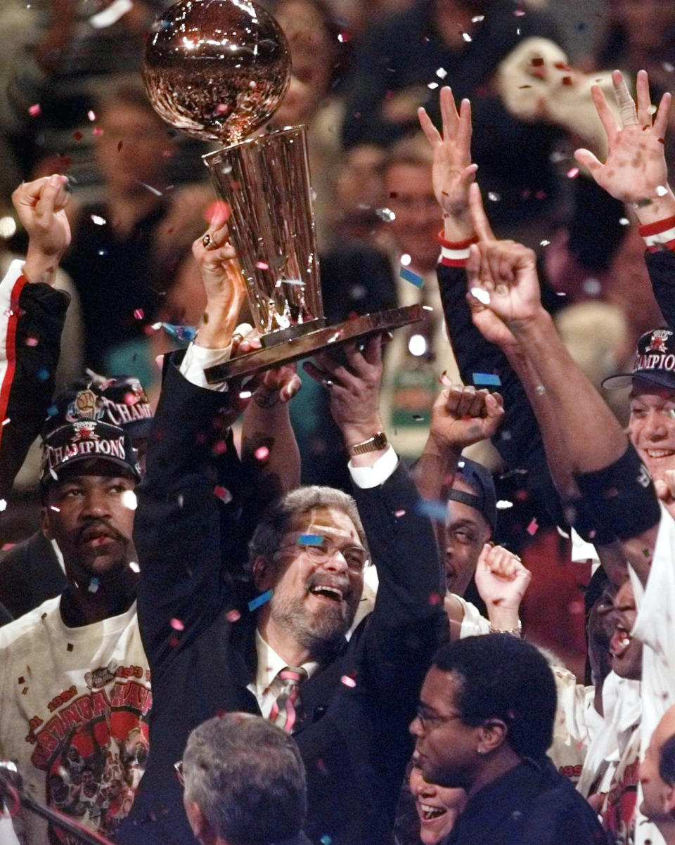 FILE - In this June 13, 1997 file photo, Chicago Bulls coach Phil Jackson hoists the trophy aloft after the Bulls beat the Utah Jazz 90-86 in Game 6 to win the NBA championship in Chicago. Jackson will be introduced as the newest member of the New York Knicks' front office Tuesday morning, according to a person familiar with the negotiations between the 11-time champion coach and the team. The person spoke on condition of anonymity on Friday, March 14, 2014, because the Knicks would only confirm that a "major announcement" involving team executives was scheduled. (AP Photo/Morry Gash, File)