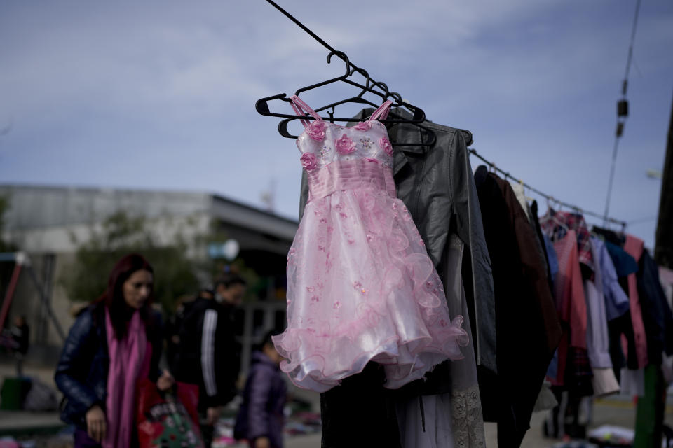 Prendas de segunda mano cuelgan en un mercado donde la gente puede intercambiar productos el miércoles 10 de agosto de 2022 en las afueras de Buenos Aires. (AP Foto/Natacha Pisarenko)