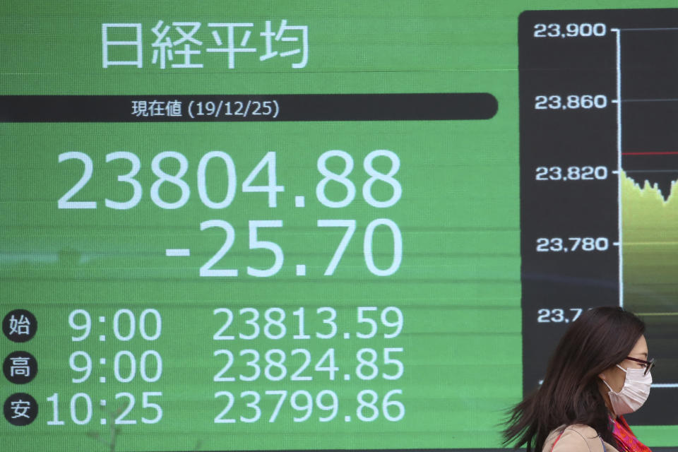 An woman walka by an electronic stock board of a securities firm in Tokyo, Wednesday, Dec. 25, 2019. Chinese and Japanese stocks declined Wednesday while most other Asian markets were closed for Christmas Day.(AP Photo/Koji Sasahara)