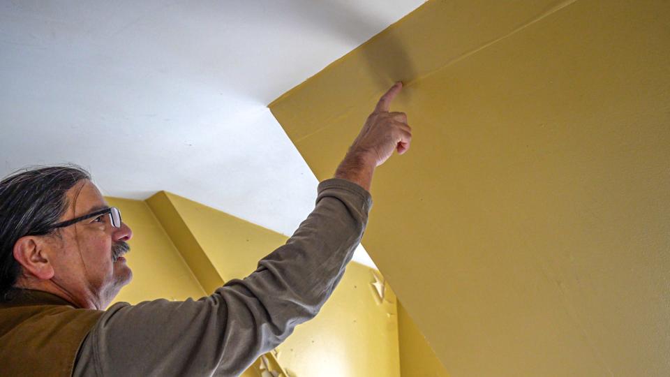 Noel Sanchez, who owns Casa Buena Builders and teaches classes with Building Works shows how bubbling paint on the top floor could be signs of water seepage during a tour of 1756 Esek Hopkins house.