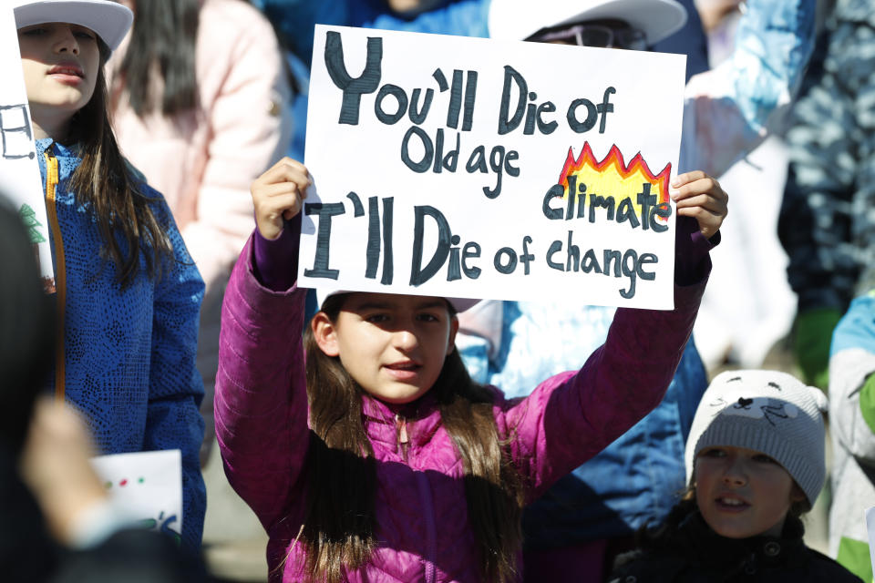 Ten-year-old Harper Phillips of Denver waves a placard as Swedish climate activist Greta Thunberg speaks to several thousand people at a climate strike rally Friday, Oct. 11, 2019, in Denver. The rally was staged in Denver's Civic Center Park. (AP Photo/David Zalubowski)