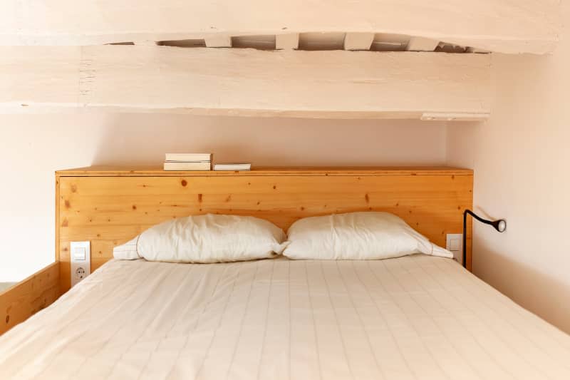 wood frame bed in white minimal loft bedroom