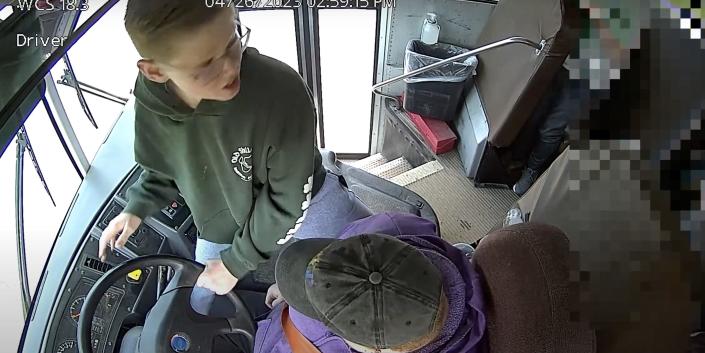 A screenshot of security-camera footage of Dylan Reeves holding the steering wheel of a school bus after the bus driver lost consciousness.