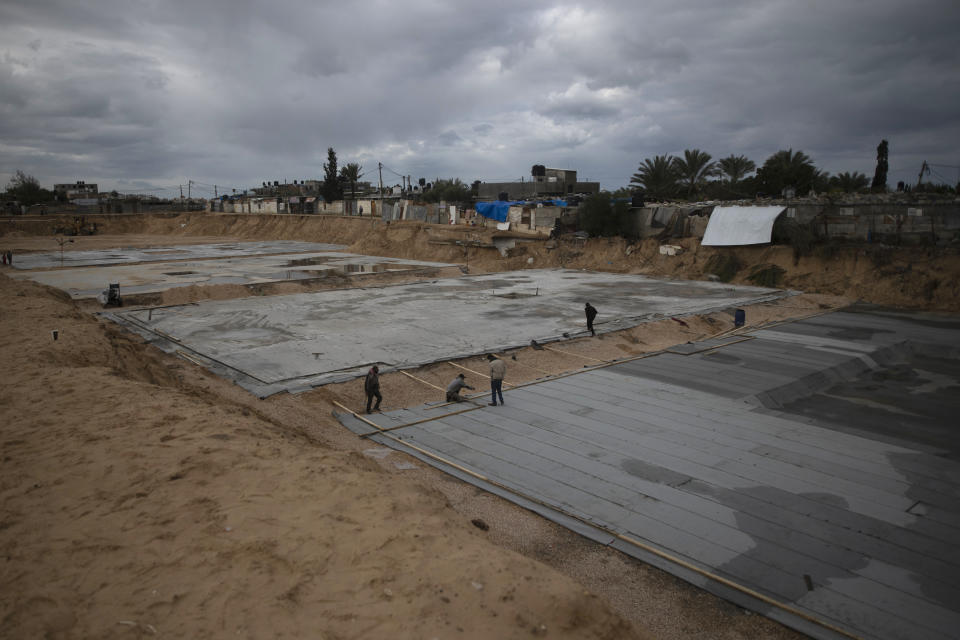 Laborers work on concrete slab foundations for one of three Egyptian-funded housing complexes in the Gaza Strip, in Beit Lahiya, northern Gaza, Jan. 20, 2022. After years of working behind the scenes as a mediator, Egypt is taking on a much larger and more public role in Gaza. In the months since it brokered a Gaza cease-fire last May, Egypt has sent crews to clear rubbled and promised to build vast new apartment complexes, and billboards of its president Abdel-Fattah el-Sissi, are a common sight. (AP Photo/Khalil Hamra)