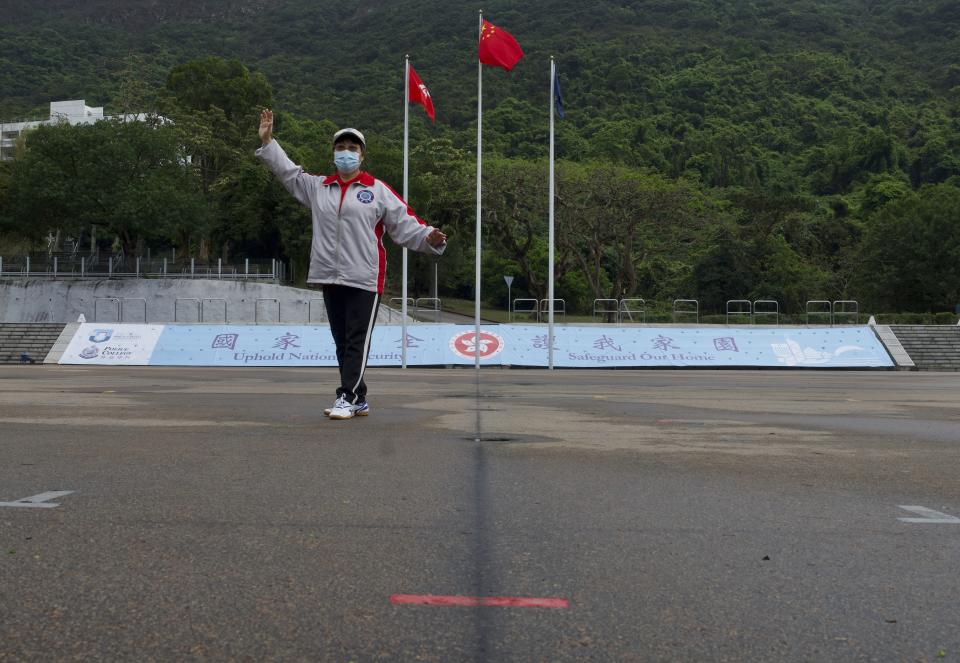 A woman poses in front of a Chinese national flag on the National Security Education Day at a police school in Hong Kong Thursday, April 15, 2021. Beijing's top official in Hong Kong on Thursday warned foreign forces not to interfere with the "bottom line" of national security in Hong Kong, threatening retaliation even amid ongoing tensions between China and Western powers. (AP Photo/Vincent Yu)