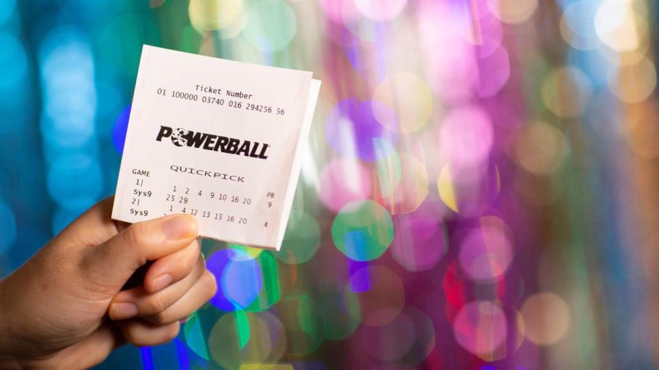 Lottery ticket for Powerball being held in a hand. 