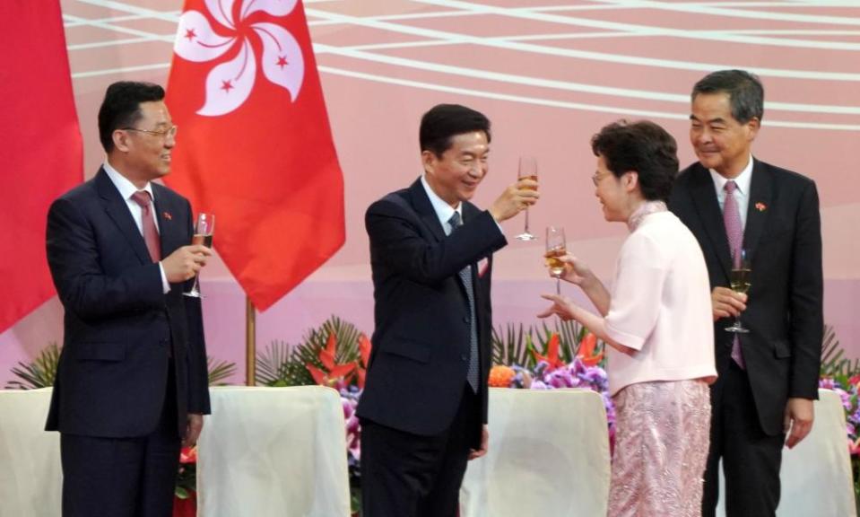 Carrie Lam and Luo Huining, clink champagne glasses at a ceremony celebrating the anniversary of the Hong Kong’s handover.