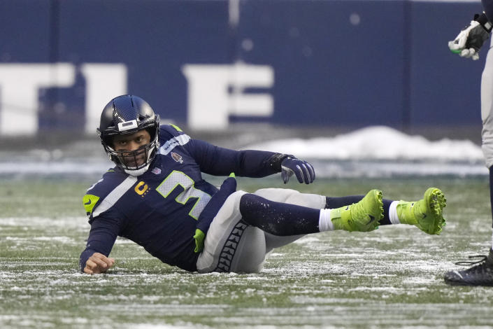 Seattle Seahawks quarterback Russell Wilson starts to right himself after being knocked to the turf during the second half of an NFL football game against the Chicago Bears, Sunday, Dec. 26, 2021, in Seattle. (AP Photo/Stephen Brashear)