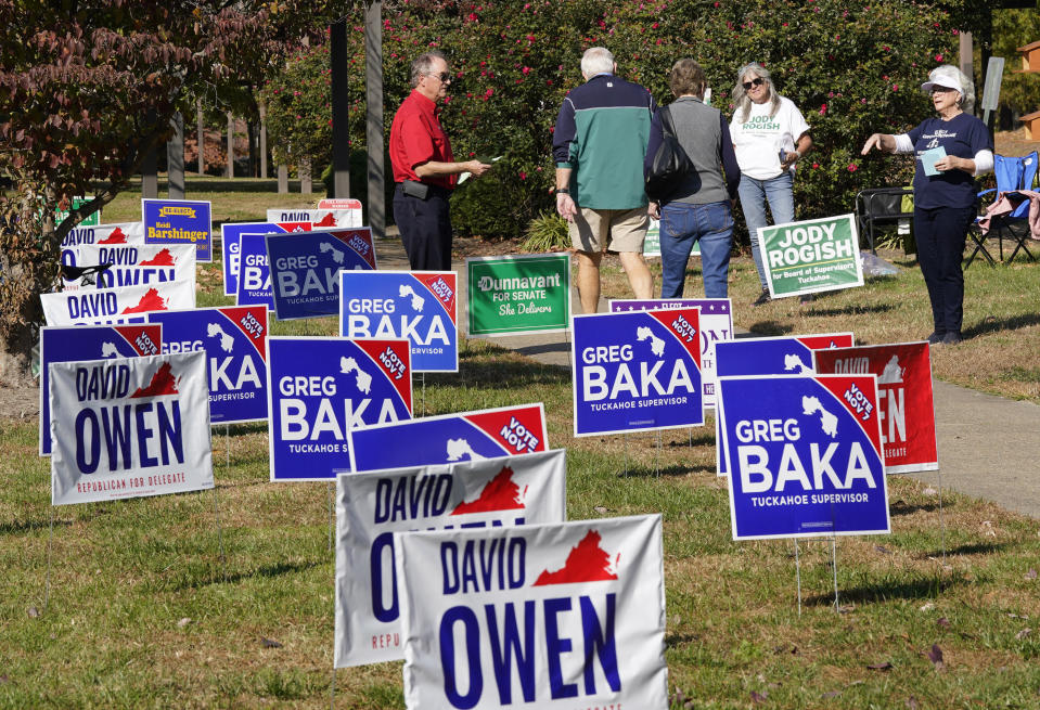 Volunteers hand out sample ballots as voters walk to a polling station Tuesday Nov. 7, 2023, in Richmond, Va. (AP Photo/Steve Helber)