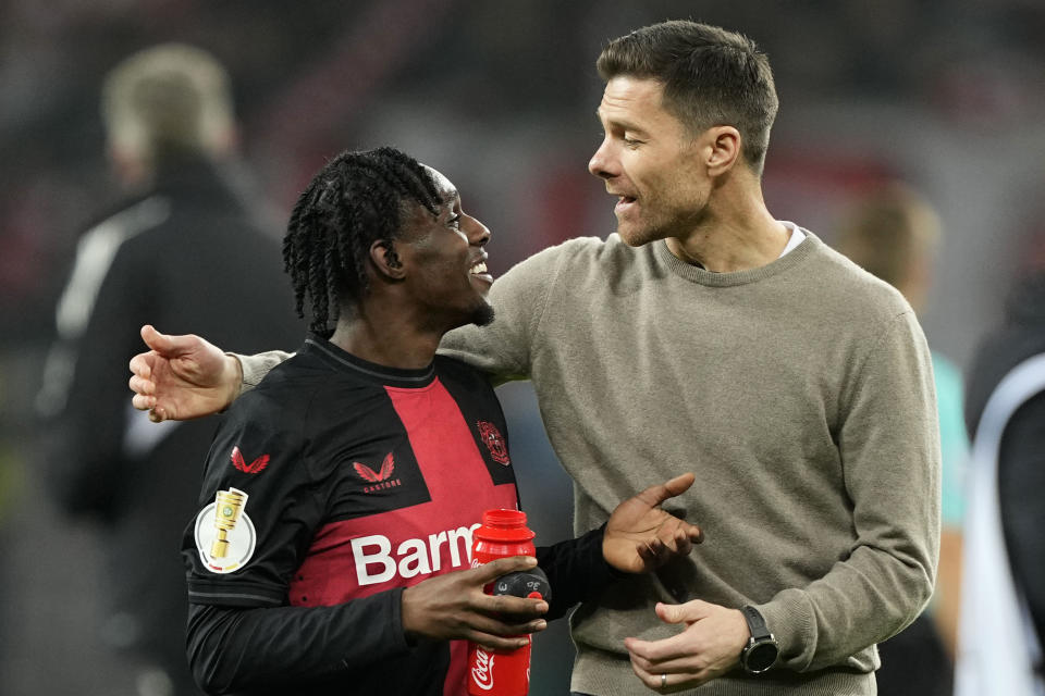 Leverkusen's head coach Xabi Alonso, right, talks to Leverkusen's Jeremie Frimpong after the German soccer cup match between Bayer 04 Leverkusen and Fortuna Duesseldorf in Leverkusen, Germany, April 3, 2024. (AP Photo/Martin Meissner)