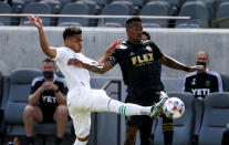 Austin FC midfielder Daniel Pereira Gil, left, and Los Angeles FC midfielder Mark-Anthony Kaye (14) vie for the ball during the first half of an MLS soccer match Saturday, April 17, 2021, in Los Angeles. (AP Photo/Ringo H.W. Chiu)