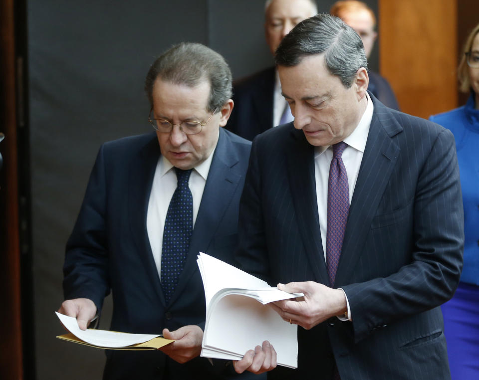 President of European Central Bank Mario Draghi, right, and vice President Vitor Constancio are on their way to a press conference following the meeting of the governing council in Frankfurt, Germany, Thursday, Feb. 6, 2014. The European Central Bank has left its benchmark interest rate unchanged, holding off on more stimulus despite weak economic growth and low inflation. The bank's 24-member governing council left the rate at 0.25 percent at a meeting in Frankfurt, Germany. Some analysts had thought the eurozone's monetary authority might cut the rate to 0.1 percent to try to boost growth more. (AP Photo/Michael Probst)