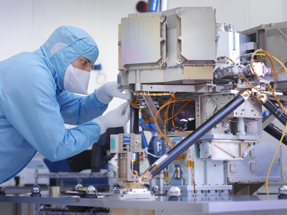 Worker building a satellite dish. Photo: Getty