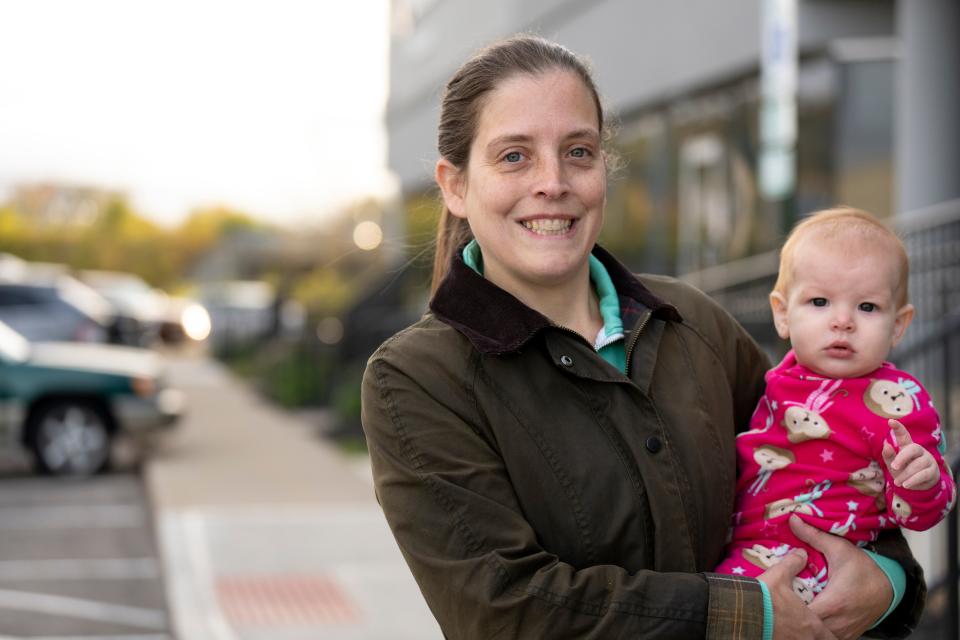 Sarah Donohue, 38, a democrat from Newtown, stands outside the Hamilton County Board of Election with her daughter, Cece, after casting an early ballot in Norwood on Wednesday, Oct. 19, 2022. 