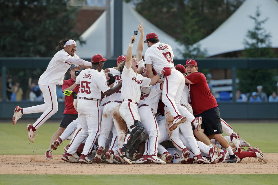 Arkansas players celebrate their win over North Carolina following an NCAA college super regional baseball game in Chapel Hill, N.C., Sunday, June 12, 2022. (AP Photo/Karl B DeBlaker)