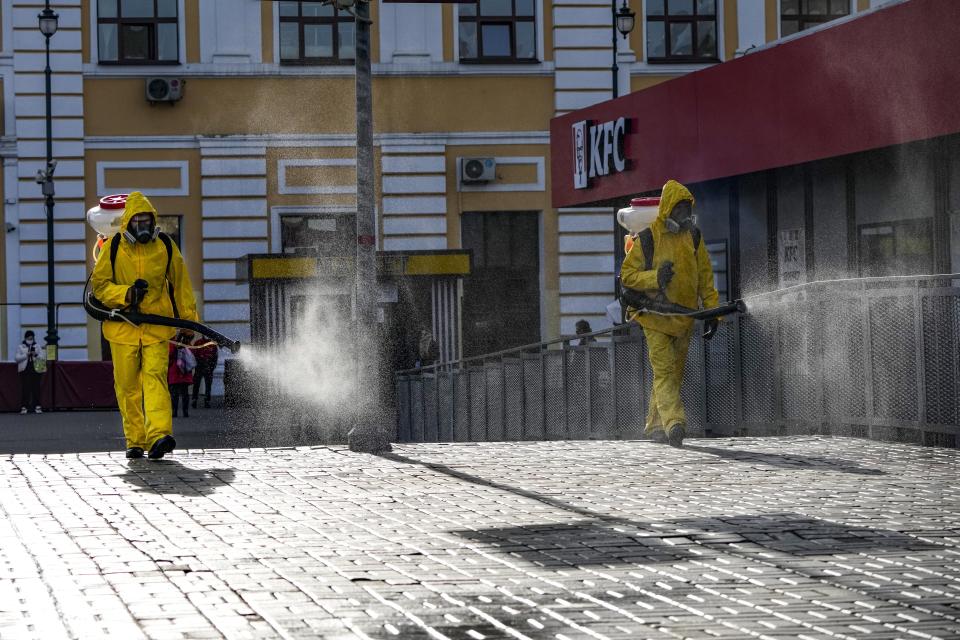 Employees of the Federal State Center for Special Risk Rescue Operations of Russia Emergency Situations disinfect Savyolovsky railway station in Moscow, Russia, Tuesday, Oct. 26, 2021. The daily number of COVID-19 deaths in Russia hit another high Tuesday amid a surge in infections that forced the Kremlin to order most Russians to stay off work starting this week. (AP Photo/Alexander Zemlianichenko)