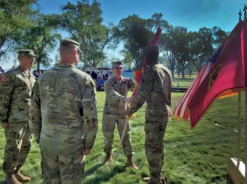 Christopher Reaves, far right, Joint Munitions Command sergeant major, passes the Tooele Army Depot flag to Col. Luke Clover, TEAD's new commander, during a change of command ceremony July 18.  Melissa Dabney-Thomas, Tooele Army Depot