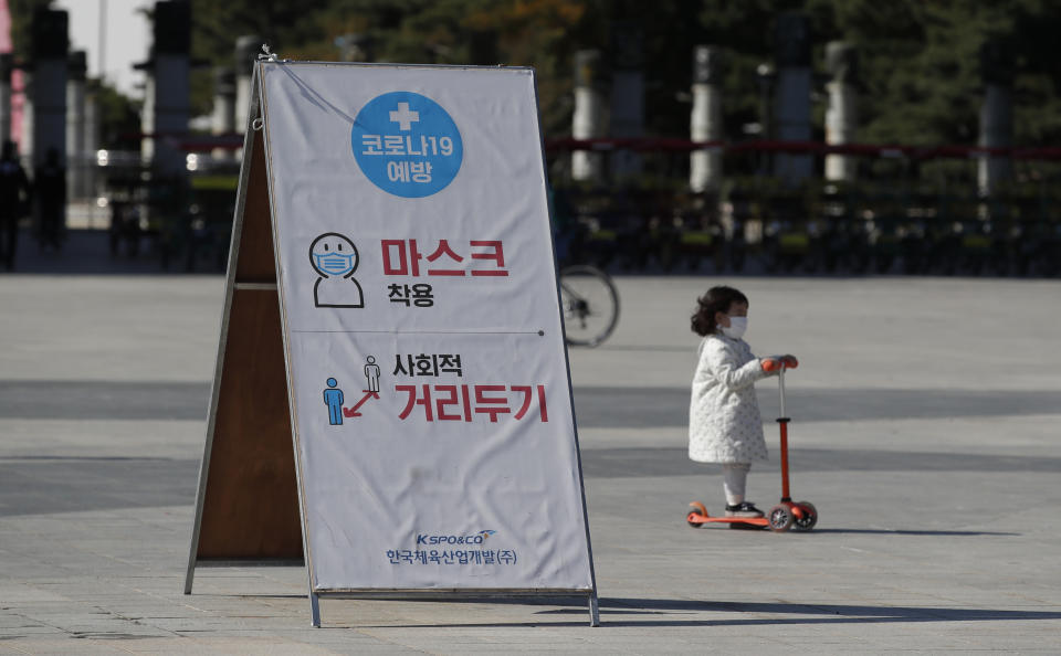 A banner showing mandatory mask wearing and social distancing as a precaution against the coronavirus, is seen at a park in Seoul, South Korea, Saturday, Oct. 24, 2020. (AP Photo/Lee Jin-man)