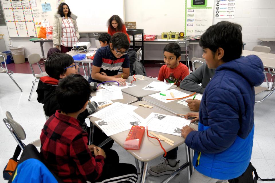 Marlboro Hindi School students complete a Christmas-themed worksheet during the Beginner 3 class run by Maya Gupta, far left, and Swathi Ojha on Saturday, December 17, 2022 at Marlboro Memorial Middle School in Marlboro, New Jersey. Gupta said she got involved with the school after enrolling her child there 20 years ago.