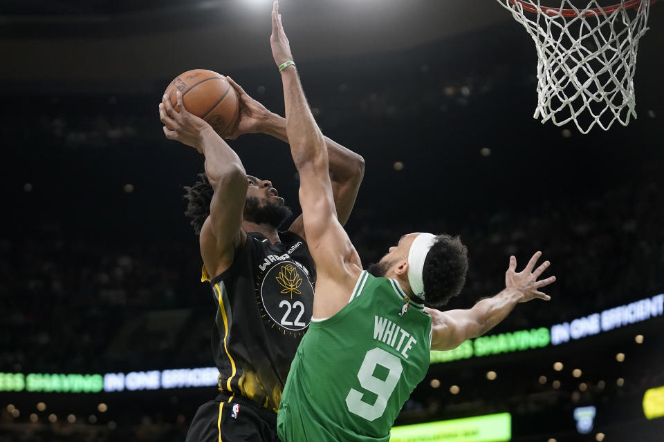 Golden State Warriors forward Andrew Wiggins (22) looks to shoot at the basket past Boston Celtics guard Derrick White (9) in the first half of an NBA basketball game, Thursday, Jan. 19, 2023, in Boston. (AP Photo/Steven Senne)