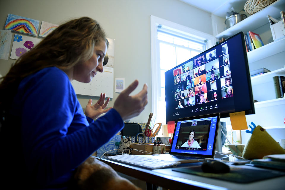 Lauryn Morley, a lower school substitute teacher for the Washington Waldorf School in Bethesda, Maryland, talks to Clare Andre (laptop), a 7th grade teacher and co-chair of the lower school, from her home due to the Coronavirus outbreak on April 1, 2020 in Arlington, Virginia. - Her role in the school changed significantly when Coronavirus hit. She was previously working part time to support teachers when they needed to be absent from the classroom and now she helps them to build skills with new digital platforms so they can continue to teach in the best way for their students and their families.The middle school (grades 6-8) has most regularly been using Zoom and the lower grades have been using Zoom with parents. (Photo by Olivier DOULIERY / AFP) (Photo by OLIVIER DOULIERY/AFP via Getty Images)