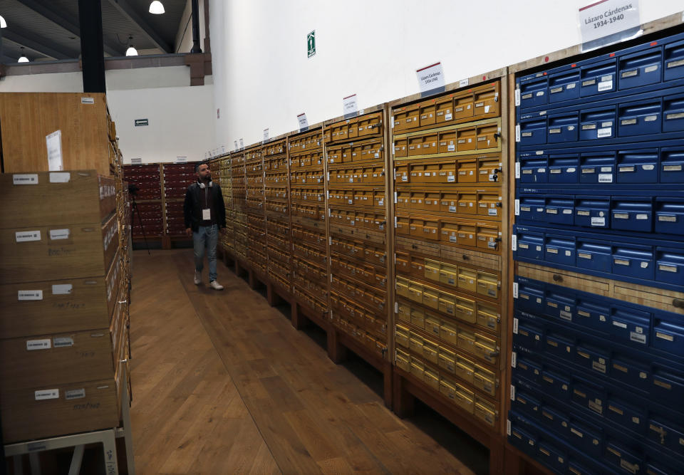 A journalists walks past stored files at the National Archive where old intelligence documents drawn up by spies in 1979 and 1980 from the now-extinct Federal Security Department are kept, during a media presentation in Mexico City, Tuesday, April 16, 2019. The government released a trove of old intelligence documents Tuesday, including a few that claimed current President Andres Manuel Lopez Obrador was a local leader of the Mexican Communist Party. (AP Photo/Marco Ugarte)