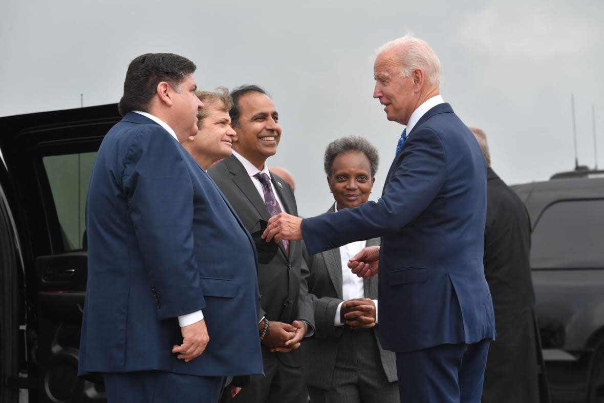 US President Joe Biden greets Chicago Mayor Lori Lightfoot (2nd-R), Illinois Governor J.B. Pritzker (L), Rep. Mike Quigley (2n-L) and Rep. Raja Krishnamoorthi (3rd-L) as he disembarks from Air Force One upon arrival at O’Hare International Airport in Chicago, Illinois, October 7, 2021, to promote the importance of Covid-19 vaccine requirements. (Photo by Nicholas Kamm / AFP) (Photo by NICHOLAS KAMM/AFP via Getty Images)