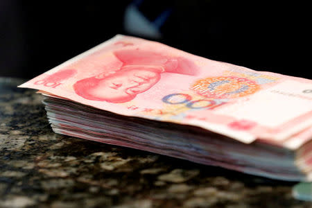 Chinese 100 yuan banknotes are seen on a counter of a branch of a commercial bank in Beijing, China, March 30, 2016. REUTERS/Kim Kyung-Hoon/File Photo