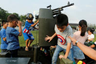 Children play with a weapon on top of an army vehicle during Children's Day celebration at a military facility in Bangkok, Thailand January 14, 2017. REUTERS/Jorge Silva