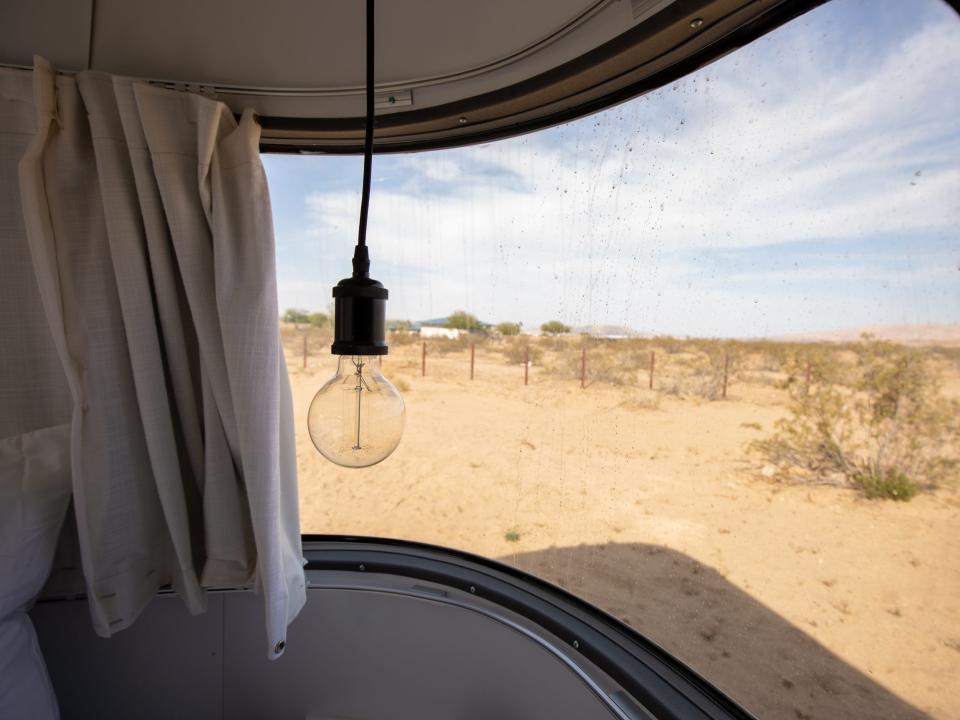 Autocamp Joshua Tree's Airsteram trailer with a window showing the outside desert.