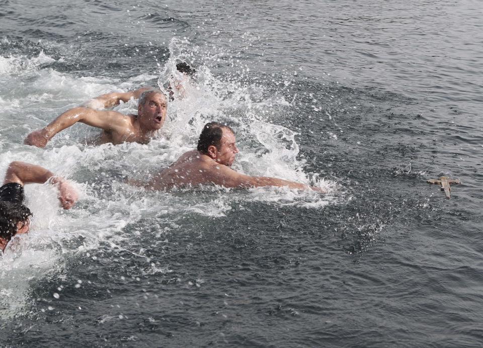 Greek Orthodox faithful Aleksandiridis swims towards a wooden crucifix in the Golden Horn in Istanbul